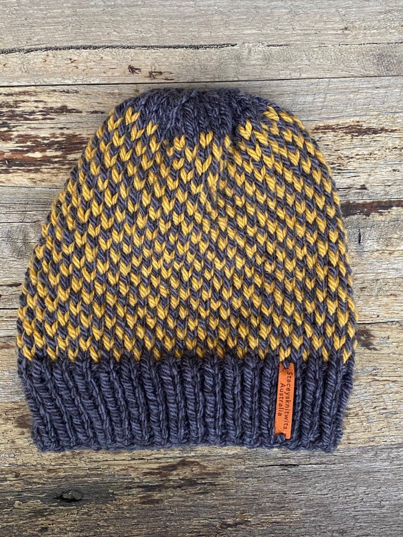 May include: A dark gray and yellow knitted beanie with a brown leather tag that reads "Staceyknits Australia".