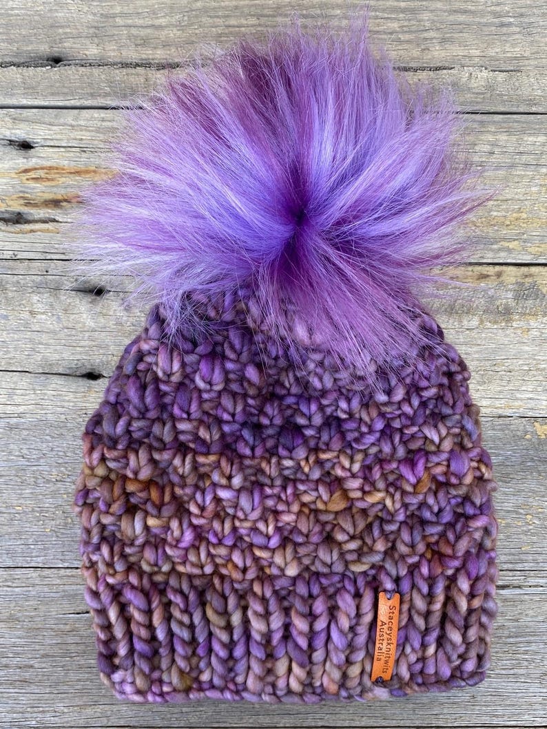 May include: Purple and brown knitted beanie with a large purple and white pom pom. The beanie has a leather tag that says "StaceyKnits Australia".