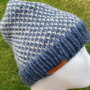 May include: A blue and white knitted beanie with a brown leather label that reads "Staceyknits Australia".