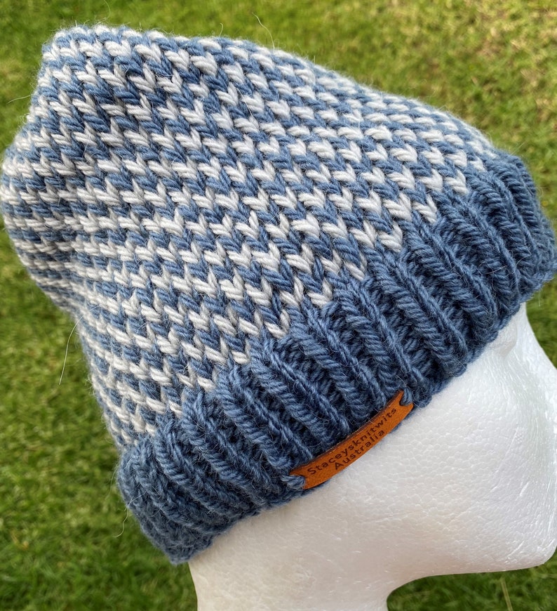 May include: A blue and white knitted beanie with a brown leather label that reads "Staceyknits Australia".