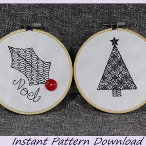 May include: Two embroidery hoops with festive designs. One shows a holly leaf with the word "Noel" and a red button. The other depicts a Christmas tree with a star. Both designs are black on white fabric, perfect for seasonal crafts.