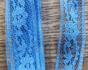 May include: A roll of blue lace trim with a floral pattern. The lace is delicate and has a soft texture.
