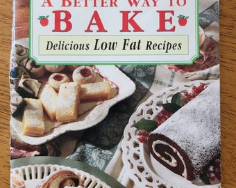 May include: A cookbook titled "Best Recipes" by Mott's, featuring the title "A Better Way to Bake" with the subtitle "Delicious Low Fat Recipes." The cover displays various baked goods on decorative plates.
