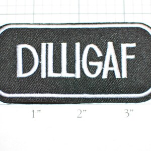 May include: Black embroidered patch with white stitching. The patch is rectangular and has a white outline. The text "DILLIGAF" is embroidered in white on the black background.
