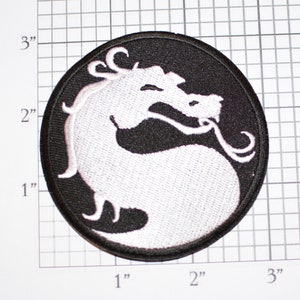 May include: White embroidered dragon logo patch on a black circular background. The patch is approximately 2 inches in diameter.