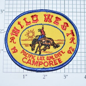 May include: A yellow and blue embroidered patch with the text "Wild West '92 Pacific Lat. Am. Dist. Camporee" and a cowboy riding a bucking horse.