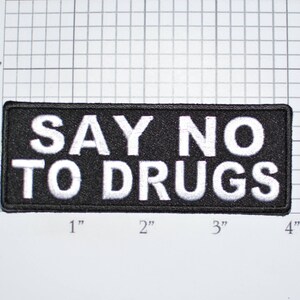 May include: Black and white embroidered patch with the text "SAY NO TO DRUGS" in white lettering on a black background.