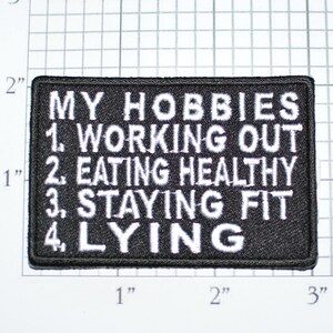 May include: Black and white embroidered patch with the text "My Hobbies 1. Working Out 2. Eating Healthy 3. Staying Fit 4. Lying"