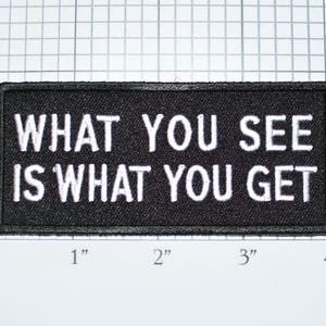 May include: Black embroidered patch with white text that reads "WHAT YOU SEE IS WHAT YOU GET".