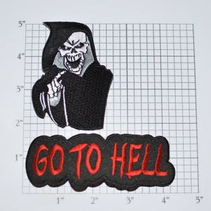 May include: Two black embroidered patches. The first patch features a black hooded figure with a white skull and the text "GO TO HELL" in red. The second patch is black with the text "GO TO HELL" in red.