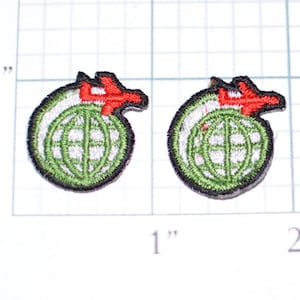 May include: Two green and white embroidered patches with a red airplane flying over a globe. The patches are about 1 inch in diameter.