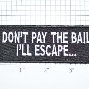 May include: Black embroidered patch with white text that reads "DON'T PAY THE BAIL I'LL ESCAPE..." The patch is approximately 3 inches wide and 1 inch tall.