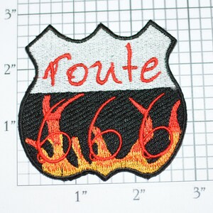 May include: Embroidered patch with a black background and red flames. The patch is shaped like a highway sign and says "Route 66" in red lettering.