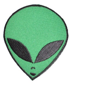 May include: Green alien face embroidered patch with black eyes.