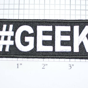 May include: Black rectangular patch with white embroidered text that reads "#GEEK".