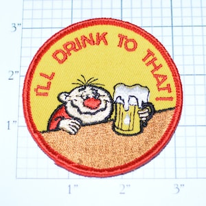 May include: A yellow and red embroidered patch with a cartoon character holding a beer mug. The text on the patch reads "I'll Drink To That!"