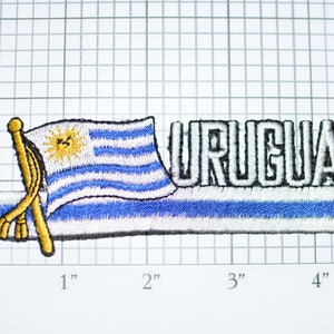 May include: Embroidered patch featuring the flag of Uruguay with the word "URUGUAY" in white lettering. The flag is blue, white, and yellow with a sun in the center.