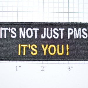 May include: Black embroidered patch with white text that reads "IT'S NOT JUST PMS IT'S YOU!"