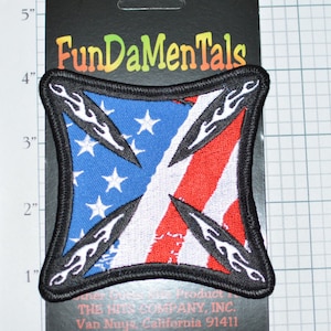 May include: A black and white embroidered patch with a stylized American flag design. The flag is divided diagonally with flames on each side. The text "FunDaMenTals" is visible on the packaging.