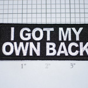 May include: Black embroidered patch with white text that reads "I GOT MY OWN BACK".