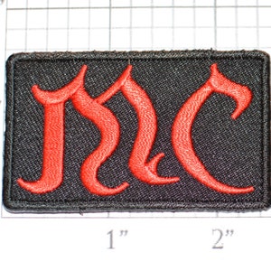 May include: Red embroidered "MC" patch on a black fabric background. The patch is approximately 1 inch by 2 inches.