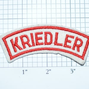 May include: White felt patch with a red embroidered border and the word "KRIEDLER" in red.