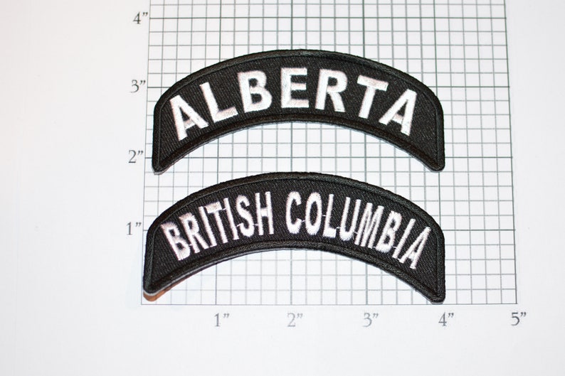 May include: Two black fabric patches with white embroidered text. The top patch reads "ALBERTA" and the bottom patch reads "BRITISH COLUMBIA".