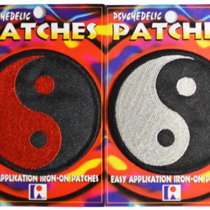 May include: Two iron-on patches featuring a yin yang symbol. The patch on the left is red and black, while the patch on the right is white and black. Both patches have the text "PSYCHEDELIC PATCHES" and "EASY APPLICATION IRON-ON PATCHES" printed on the packaging.