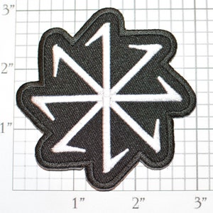 May include: A black embroidered patch with a white eight-pointed star design. The star is made up of eight arrows pointing in different directions.