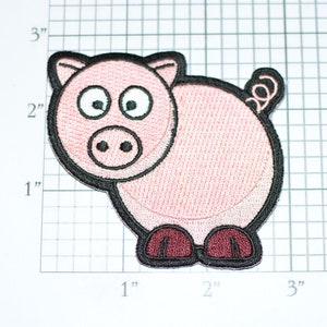May include: A pink cartoon pig with black eyes and a black outline. The pig is about 2 inches tall and 2 inches wide.