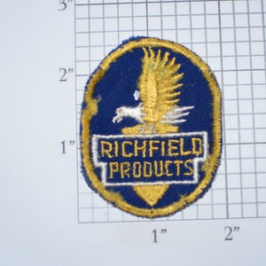 May include: A blue and gold embroidered patch with a white eagle and the text "Richfield Products".