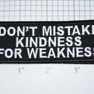 May include: Black embroidered patch with white text that reads "Don't mistake kindness for weakness".
