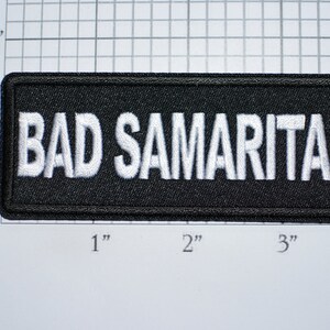 May include: Black embroidered patch with white text that reads "BAD SAMARITAN".