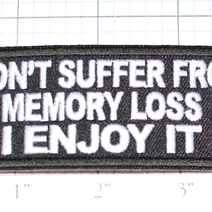May include: Black embroidered patch with white text that reads "I don't suffer from memory loss I enjoy it".