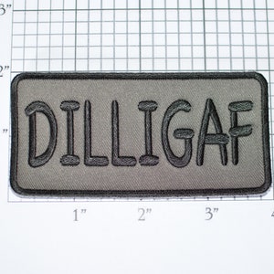 May include: A rectangular patch with the word "DILLIGAF" embroidered in black on a gray background. The patch has a black border and is approximately 4 inches wide and 2 inches tall.