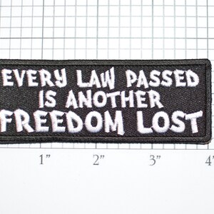 May include: Black embroidered patch with white text that reads "Every law passed is another freedom lost".
