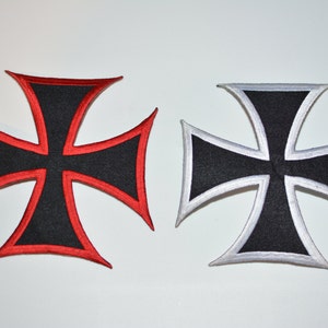 May include: Two iron cross patches, one with a red border and one with a silver border. Both patches are black with a white cross in the center.