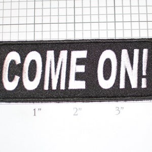 May include: Black embroidered patch with white lettering that reads "COME ON!" The patch is approximately 3 inches wide and 1 inch tall.