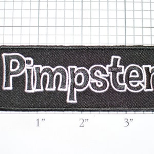 May include: Black embroidered patch with white outline, reading "Pimpster".