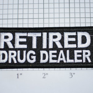 May include: Black embroidered patch with white text that reads "Retired Drug Dealer".