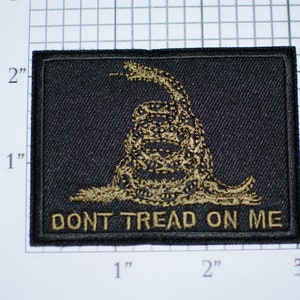 May include: A black fabric patch with a gold embroidered image of a coiled rattlesnake with the words "Don't Tread On Me" below it.
