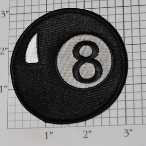 May include: Black and white embroidered patch of a billiard ball with the number 8 on it. The patch is 2 inches in diameter.