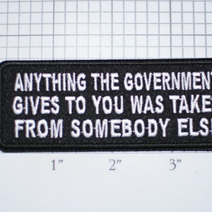 May include: Black and white embroidered patch with the text "Anything the government gives to you was taken from somebody else".