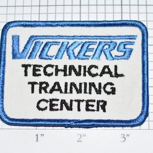 May include: A blue and white embroidered patch with the text "VICKERS TECHNICAL TRAINING CENTER".