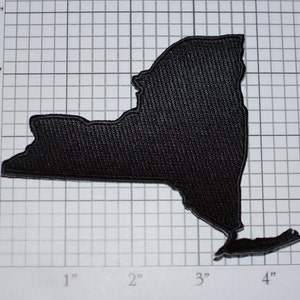 May include: Black felt outline of the state of New York, measuring approximately 4 inches wide and 3 inches tall.
