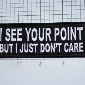 May include: Black and white embroidered patch with the text "I SEE YOUR POINT BUT I JUST DON'T CARE".