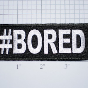 May include: Black iron-on patch with white embroidery that reads "#BORED" in all caps. The patch is approximately 3 inches wide and 1 inch tall.
