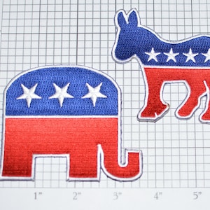 May include: Two embroidered patches, one red and blue elephant and one red and blue donkey, both with white stars. The patches are on a white grid background.