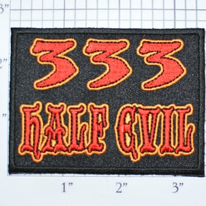 May include: Black rectangular patch with red embroidered text. The top line reads "333" and the bottom line reads "HALF EVIL". The text has a yellow outline. The patch measures approximately 3 inches by 2 inches.