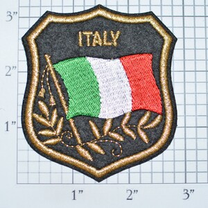 May include: A gold embroidered patch with a black background featuring the Italian flag and the word "ITALY".